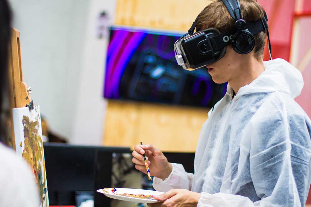A boy playing a virtual reality painting game.
